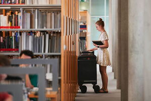 Bibliothek im Karlsruher Institut für Technologie (KIT) Eine Frau steht vor einem Regal in einer Bibliothek