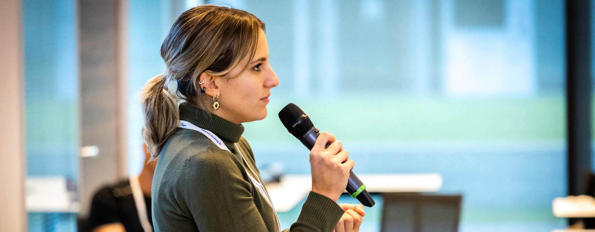 Qustec PhD candidate A woman with a microphone