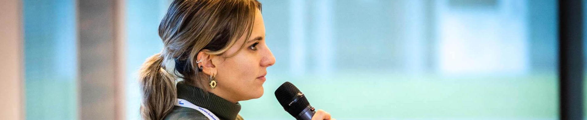 QUSTEC Doktorandin Eine Frau mit einem Mikrofon